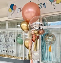 a bunch of balloons and tassels in front of a store