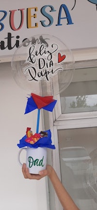 a man holding up a balloon with the word dad on it