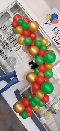 a woman is holding a bunch of balloons in front of a store