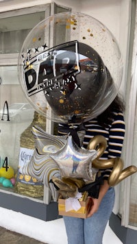 a woman standing in front of a store holding a balloon