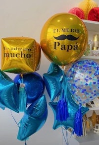 a group of balloons with the words'papa' and tassels