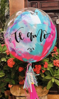 a blue and pink balloon with a tassel hanging from it