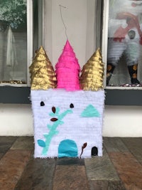 a pink and gold pinata with a castle on it