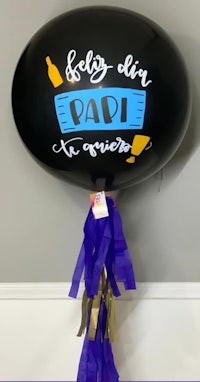 a black balloon with purple tassels hanging from it