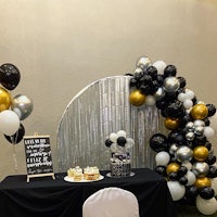 a table with balloons and a cake on it