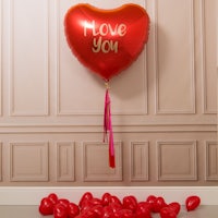 a red heart shaped balloon with the words i love you