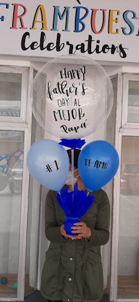 a woman holding a balloon that says happy father's day